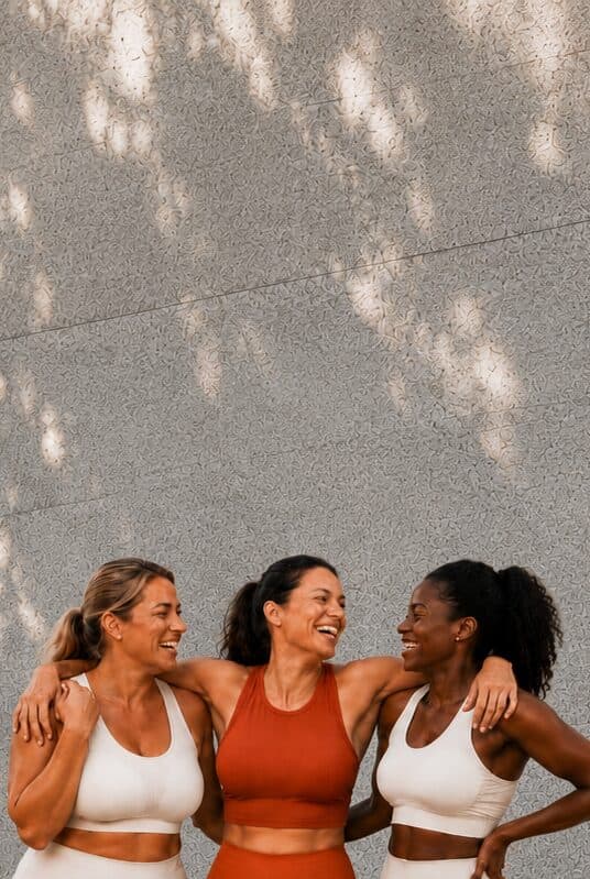 Three women laughing together outdoors
