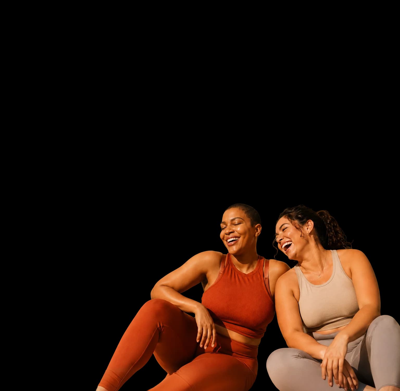 Two women in athletic wear laughing together